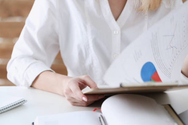 istock Female hands hold clipboard pad with financial statistics 832105810