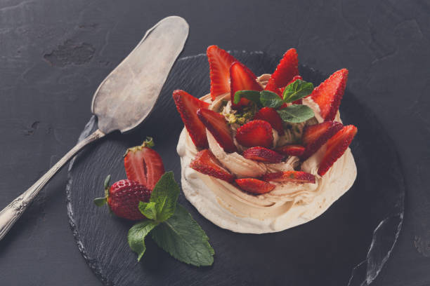 istock Anna Pavlova cake with strawberry on black background 832108010