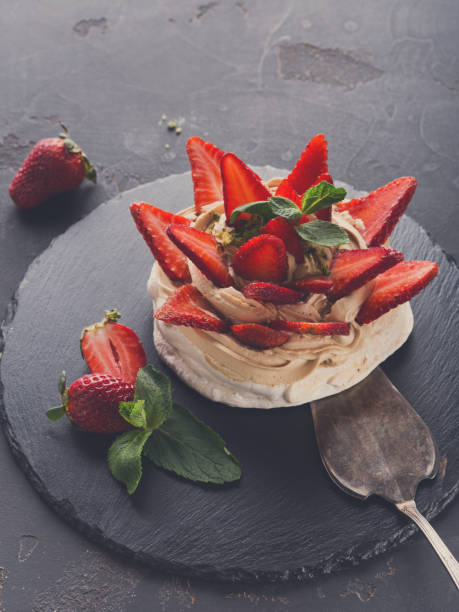 istock Anna Pavlova cake with strawberry on black background 832108090