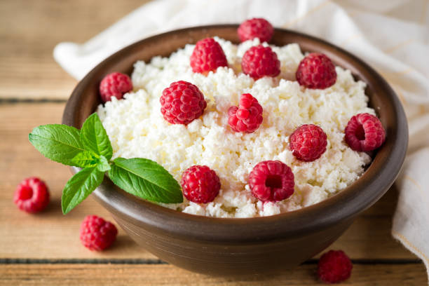 istock Cottage cheese with raspberry and mint in ceramic bowl on rustic wooden table 832108114