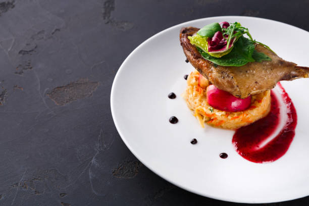 istock Restaurant meals. Duck confit with vegetables on black background 832109150