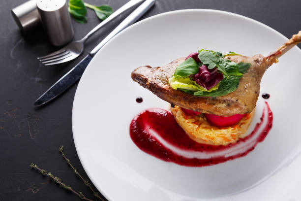 istock Restaurant meals. Duck confit with vegetables on black background 832109266