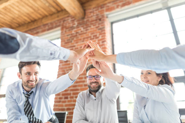 istock Happy business team giving high five in office. 832111590