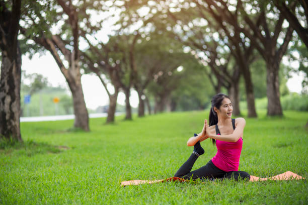 istock Young woman practicing yoga in park 832117224