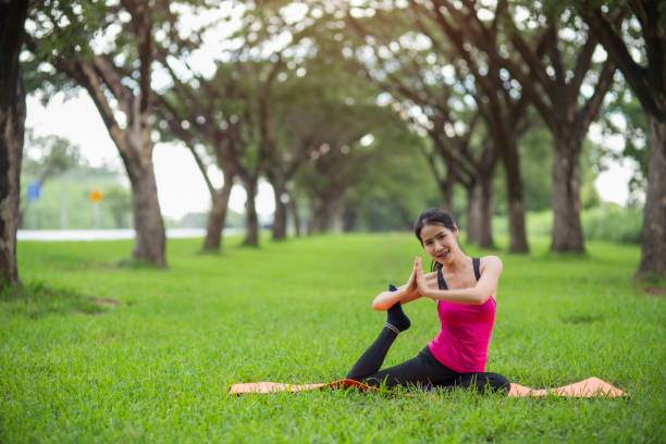 istock Young woman practicing yoga in park 832117238
