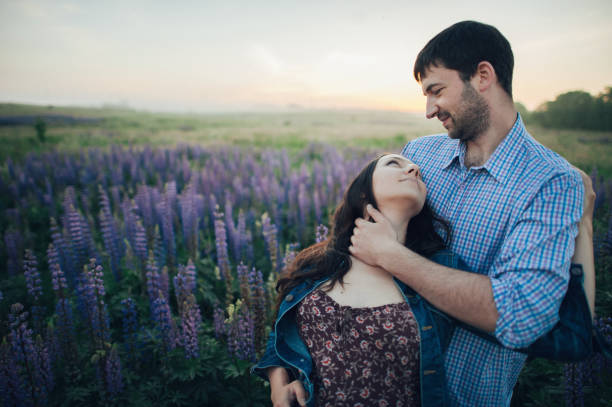 istock Young couple enjoying the sunset in the meadow 832120018