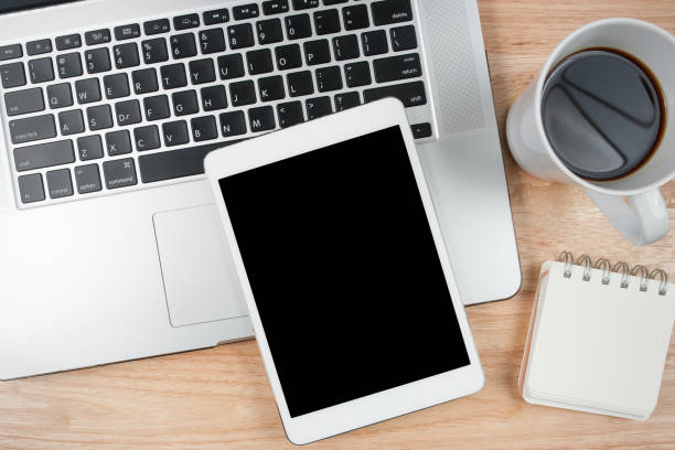 istock Tablet computer with blank screen on top wood table. Top view. 832120110