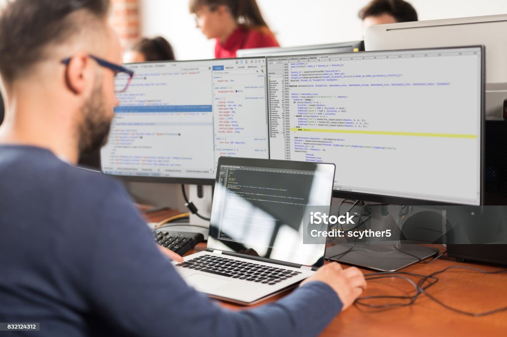 Website design. Developing programming and coding technologies. Developing programming and coding technologies. Website design. Programmer working in a software develop company office. Computer Programmer Stock Photo