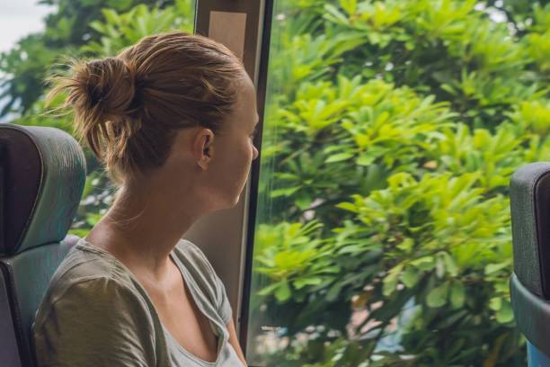 istock beautiful young woman taking bus to work 832129058