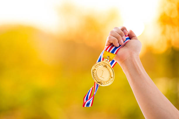 istock Number 1 winner holding medal gold award 832129200