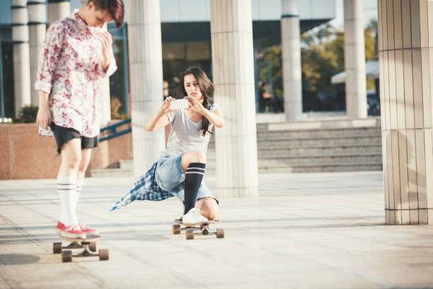 istock Girl photographing friend skateboarding 832133708