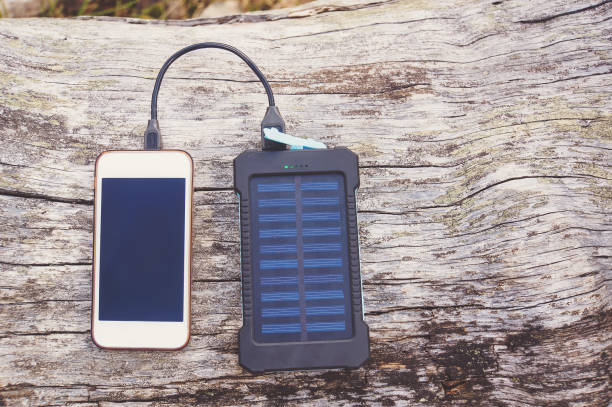 istock Smartphone charging with pink power bank on wood background 832137744