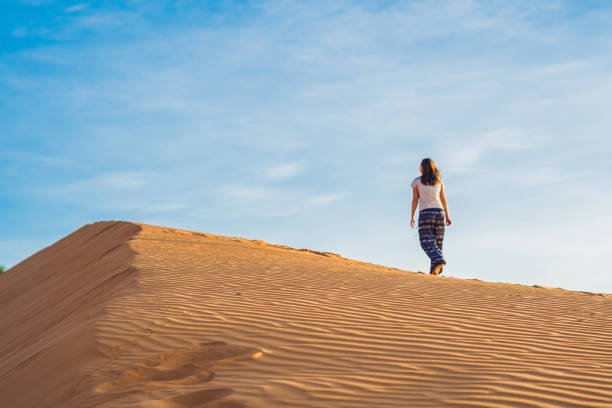 istock young woman in rad sandy desert at sunset 832142196