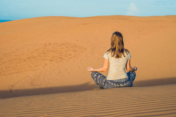 istock young woman meditating in rad sandy desert at sunset 832142198