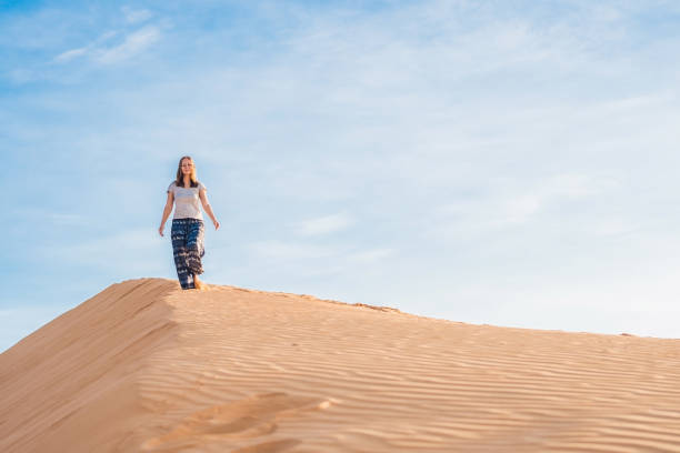 istock young woman in rad sandy desert at sunset 832142206