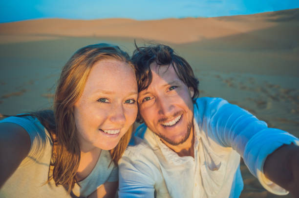 istock Couple taking selfie on sand dunes in Vietnam 832142304