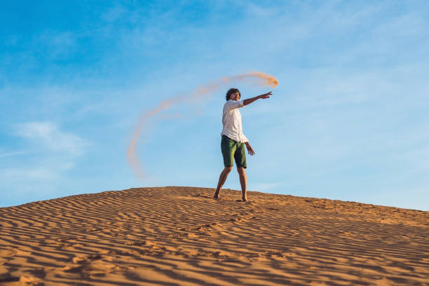 istock A man is kicking sand in a red desert. Splash of anger concept 832143752
