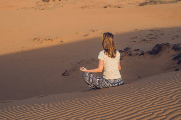 istock young woman meditating in rad sandy desert at sunset 832143770