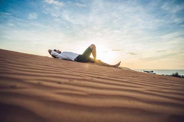 istock A man sits on the sand in the desert 832143788
