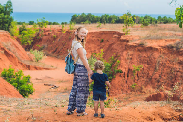 Mother and son travelers in red canyon near Mui Ne, southern Vietnam. Traveling with children concept Mother and son travelers in red canyon near Mui Ne, southern Vietnam. Traveling with children concept. mui ne bay photos stock pictures, royalty-free photos & images