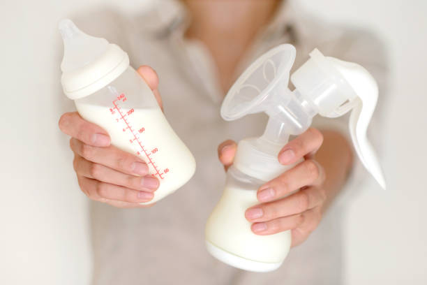 istock Breast pump and bottle with milk in woman's hand 832147122