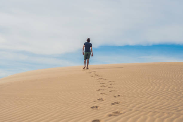 istock A man is walking in the desert Vietnam, Mui Ne 832147210