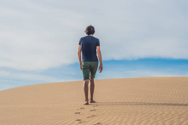 istock A man is walking in the desert Vietnam, Mui Ne 832147218
