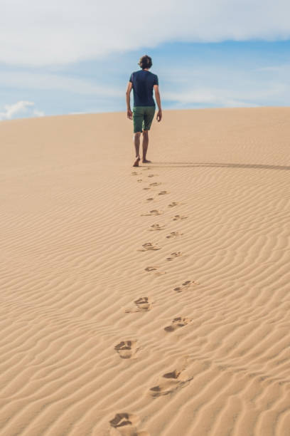 istock A man is walking in the desert Vietnam, Mui Ne 832147228