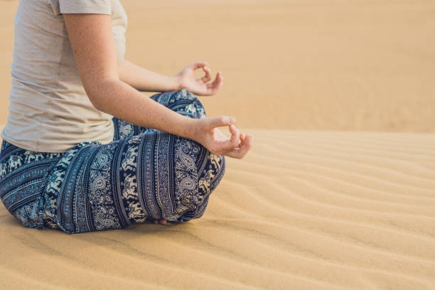 istock Young woman meditating in the desert 832147344