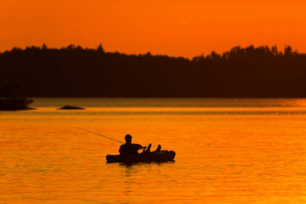 lake scene fisherman fishing at ely, boundary water canoe area, minnesota, usa at sunset - boundary waters canoe area imagens e fotografias de stock