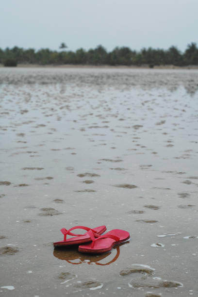 istock Red thongs in reflecting sand 832151054
