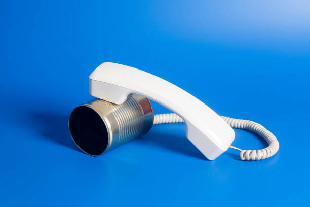 istock Tin can phone with handset on blue background. 832155916