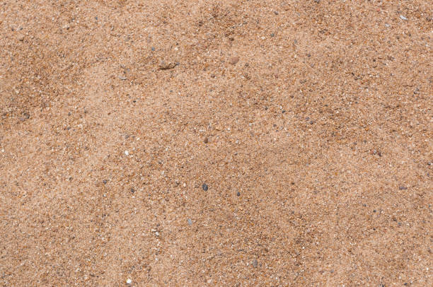istock Closeup to Brown Sand on Ground Background 832159942