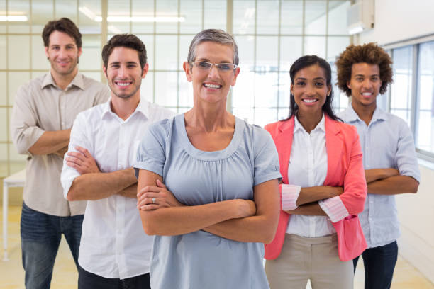 istock Leader and staff standing smiling with arms crossed 832165830