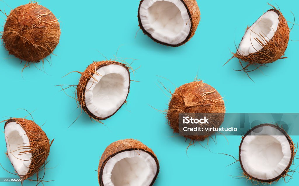 Coconut pattern on a blue background. Half and whole coconuts. Repetition concept. Top view Coconut Stock Photo