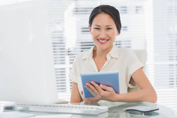istock Smiling businesswoman using digital tablet at desk 832167330