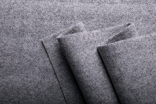Grey herringbone tweed fabric, herringbone textile background for fashion designers.