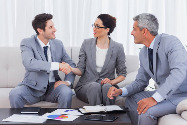 istock Happy business people working and talking together on sofa 832169756