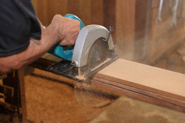 istock Industrial worker using circular miter saw for cutting wooden boards in carpentry workshop. 832170568