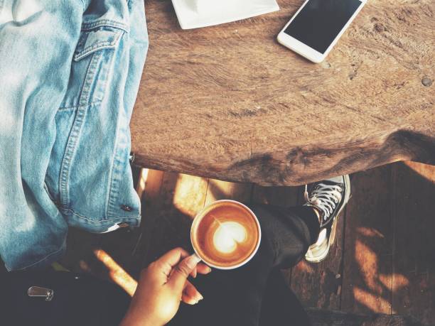 istock Woman drinking coffee and cake with smart phone on office table 832171018