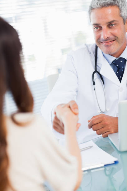 istock Smiling doctor shaking hands with his patient 832173718
