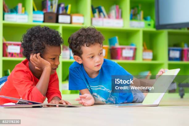 Zwei Junge Kind Legte Sich Auf Den Boden Und Lesen Märchen Buch Im Vorschulalter Bibliothek Kindergarten Schule Bildungskonzept Stockfoto und mehr Bilder von Kind