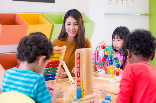 Asian female teacher teaching mixed race kids play toy in classroom,Kindergarten pre school concept Asian female teacher teaching mixed race kids play toy in classroom,Kindergarten pre school concept. teacher classroom child education stock pictures, royalty-free photos & images
