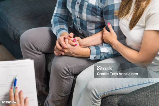 Couples Therapy Or Marriage Counseling Man And Woman Holding Hands On Couch During A Psychotherapy Session Psychologist Counselor Therapist Psychiatrist Or Relationship Consultant Giving Advice Stock Photo - Download Image Now