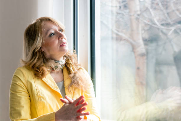 istock Sad woman looking through the window 832191978