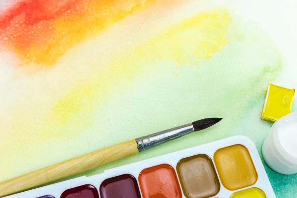 istock bright yellow background and paintbrush with watercolor palette 832192112