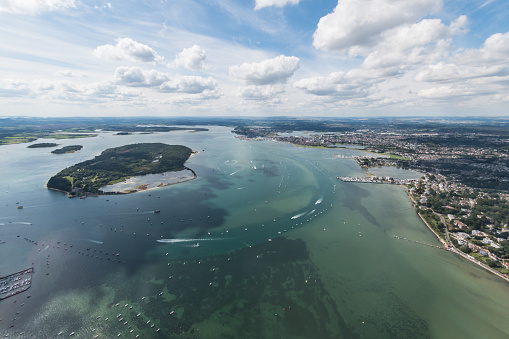 Aerial view of Poole Harbour and Brownsea Island and Dorset coastline on a sunny day.