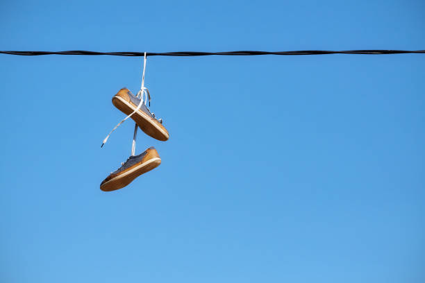 9th Street, Long Island City, Queens, New York, USA – May 10, 2018: Bunch of shoes hanging from a electric wire