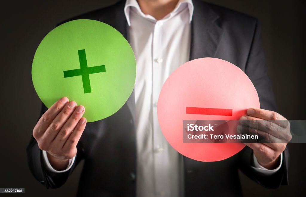 Pros and cons concept. Business man with cardboard plus and minus symbol signs. Pros and cons concept. Positive Emotion Stock Photo