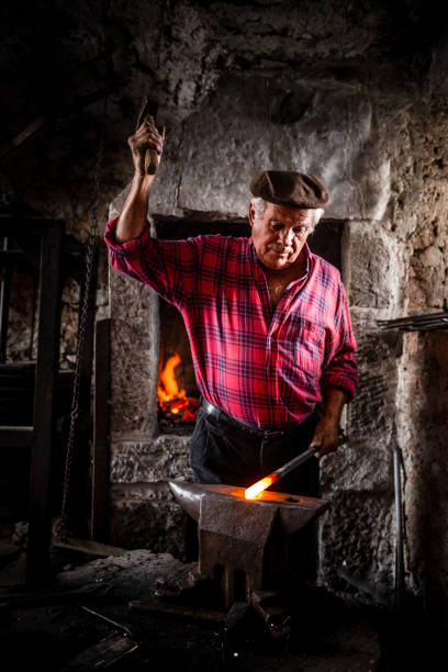 istock Senior Blacksmith Man Forging Iron Craft on Anvil 832254214